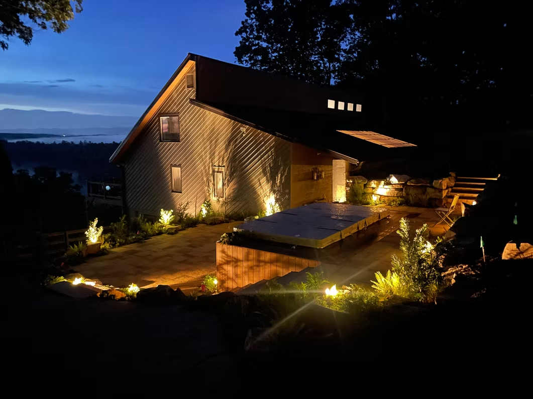 Hillside home with spa and landscape lighting at night
