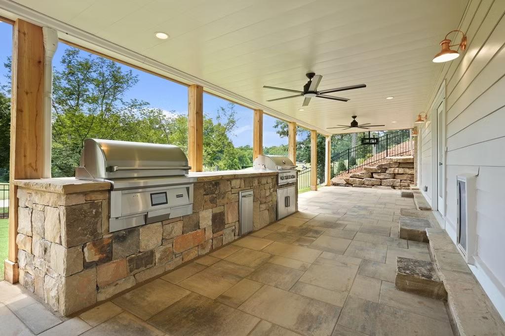 Covered outdoor kitchen with stone bar and grill
