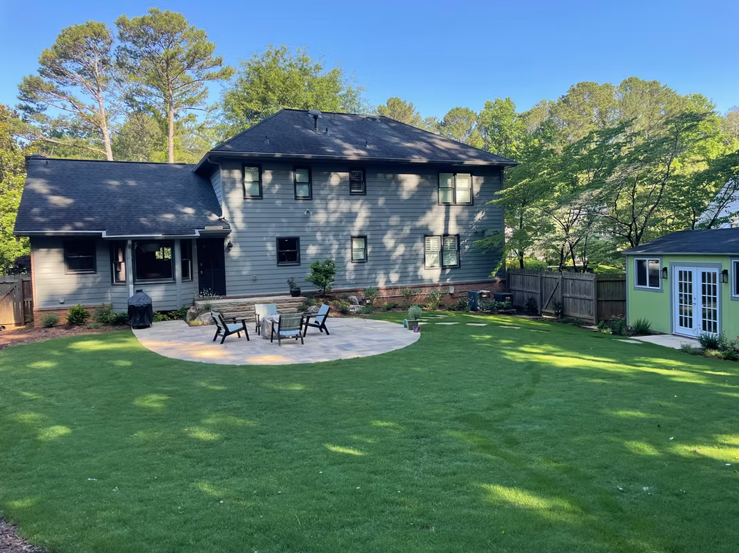 Backyard patio with dining area and lawn