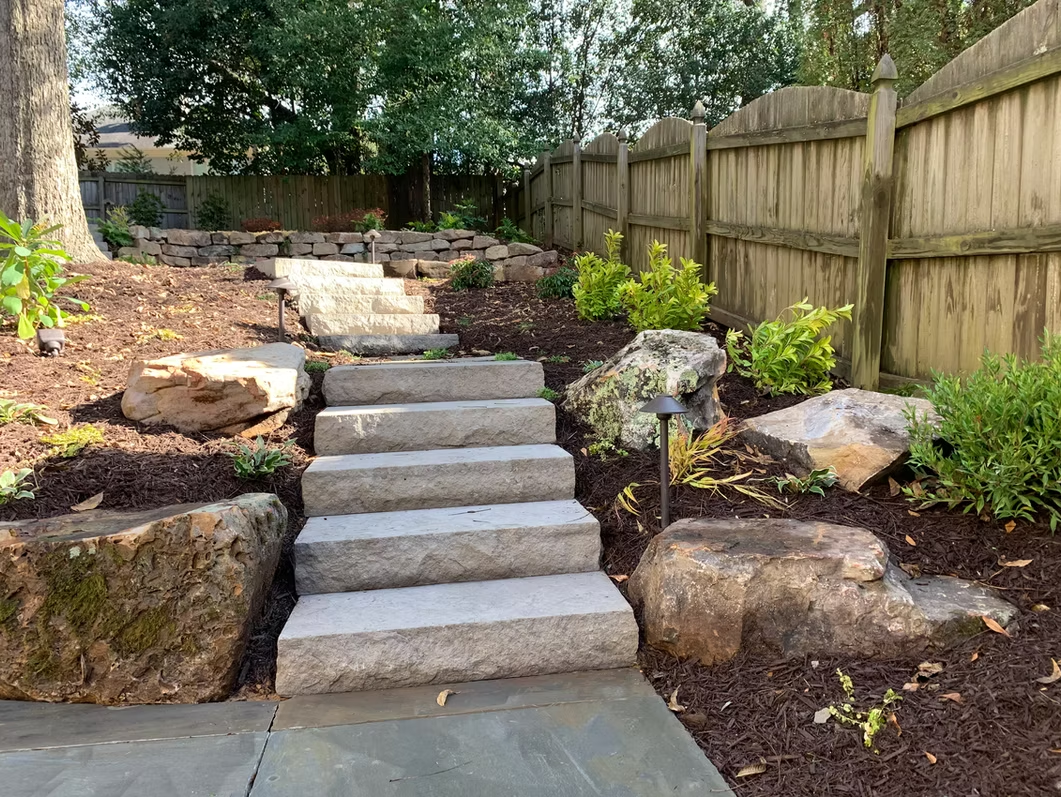 Stone steps framed by boulders and plantings
