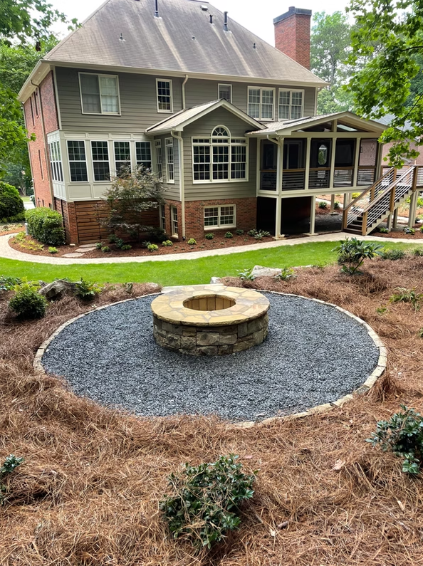 Circular fire pit patio behind a home