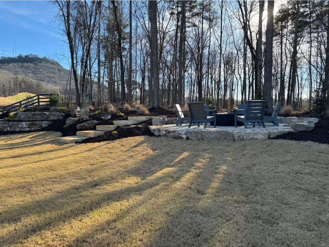 Fire pit seating area with retaining wall and lawn