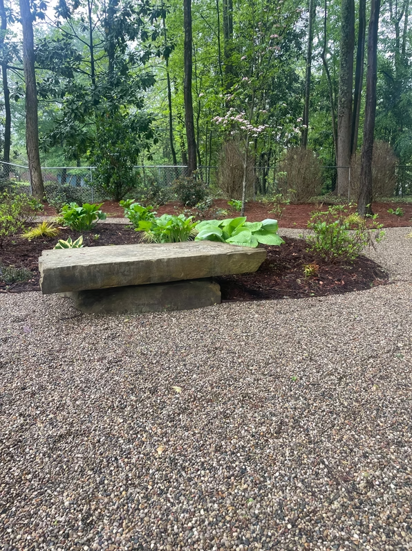 Carved stone bench in a gravel garden